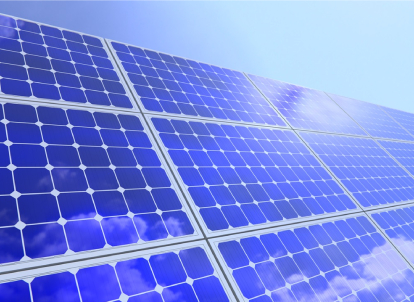 Close-up of blue solar panels under a clear sky.